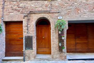 ein Eingang zu einem Backsteingebäude mit einer Holztür in der Unterkunft Casa Luisetta in Città della Pieve