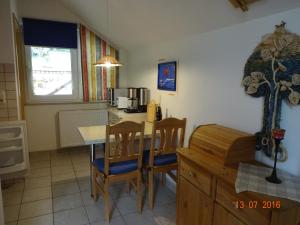 eine Küche mit einem Tisch und Stühlen sowie eine Küche mit einer Theke in der Unterkunft Ferienwohnung Hermannstein in Ilmenau