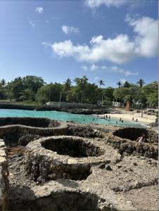 une vue d'une plage avec des gens dans l'eau dans l'établissement Santo Domingo Tropical Peaceful Escape Ocean Front Near Boca Chica Airport, à La Golondrina