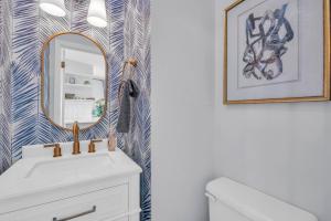 a bathroom with a white sink and a mirror at Tipsy Traveler in North Topsail Beach +37 photos