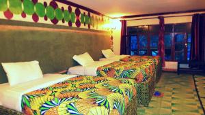 a hotel room with two beds and a window at Le Bambou Gorilla Lodge in Ruhengeri