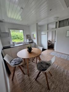 a living room with a table and chairs and a kitchen at P7 Gardens - Close to station and nature in Kokkedal