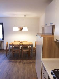 a kitchen and dining room with a table and chairs at Appartamenti Gosetti in Mezzana +13 photos