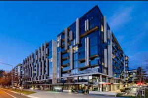 un immeuble de bureaux avec une façade bleue sur une rue dans l'établissement Plush 221 Midnight Braddon 2bedroom 2bathroom Free parking Free wifi, à Braddon