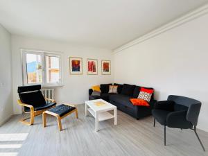 een woonkamer met een zwarte bank en stoelen bij Domus Fersina in Trento +32 foto's