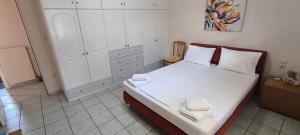 a bedroom with a white bed with two towels on it at Διαμέρισμα στο Ρίο Πατρών in Rio