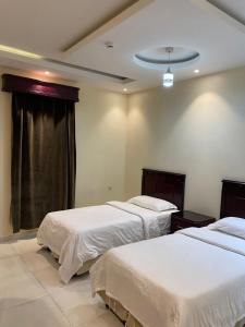 una camera da letto con due letti e una finestra di المساكن الذهبيه للشقق المخدومه a Khamis Mushayt Altre 16 foto