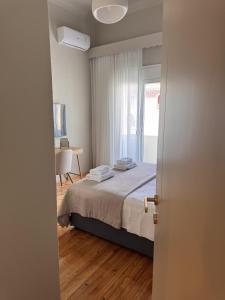 a bedroom with a bed and a table and a window at Aristotelous View Suites - Smooth Living in Thessaloniki