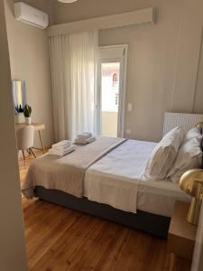 a bedroom with a bed and a table and a window at Aristotelous View Suites - Smooth Living in Thessaloniki