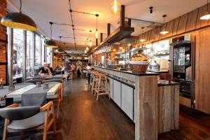 a restaurant with a bar with people sitting at tables at Lettia Aparthotel in Jūrmala