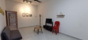 a living room with a couch and a red chair at Hey homestay melaka in Melaka