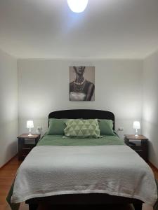 a bedroom with a large bed with two night stands at Casa Turismo Freirina in Freirina
