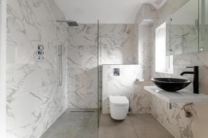 a bathroom with a sink and a toilet and a shower at Luxurious Relaxing 5 Bed House for great comfort in Lutterworth +20 photos