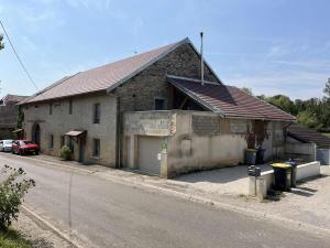a brick house with a garage on the side of a street at Grange de Courbey in Chambornay-lès-Pin