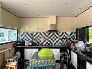a kitchen with a table with a green bowl on it at 359รีสอร์ท in Ban Tha Kasem