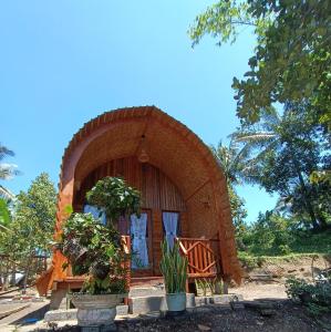 a small house with a large doorway in a yard at Tetebatu flower in Tetebatu
