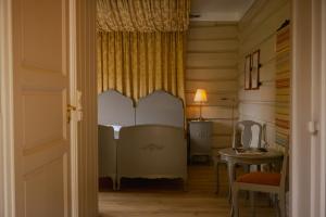 una camera da letto con un letto e un tavolo con una lampada di Røisheim Hotel & Skysstasjon a Lom