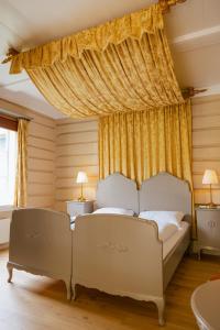 una camera da letto con due letti bianchi e tende di Røisheim Hotel & Skysstasjon a Lom