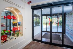 a store front with glass doors and a sign that reads tokyo at AN Hotel Milano San Donato in San Donato Milanese