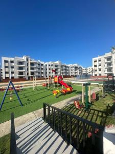 - une aire de jeux dans un parc avec un grand bâtiment dans l'établissement Santo Domingo Tropical Peaceful Escape Ocean Front Near Boca Chica Airport, à La Golondrina
