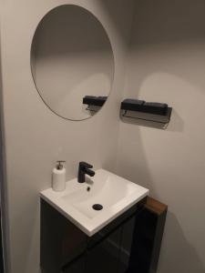 a bathroom with a white sink and a mirror at Tokapa, a place between worlds in Cape Town