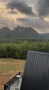カオソックにあるKhaosok Campsiteのベンチとテーブルと山のあるデッキ