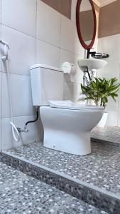 a bathroom with a toilet with a mirror and a plant at Tetebatu flower in Tetebatu