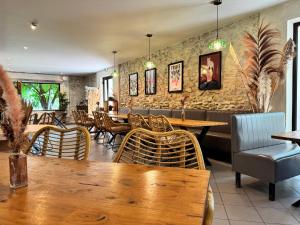 un ristorante con tavoli e sedie e un muro di pietra di Hotel Le Galambre a Nîmes