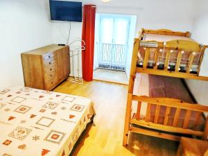 a bedroom with a bunk bed and a dresser at Maison proximité station de ski le lioran in Laveissière