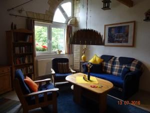 a living room with a blue couch and a table at Ferienwohnung Hermannstein in Ilmenau