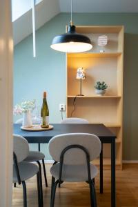 una mesa de comedor con 2 sillas y una botella de vino en Harbor-View Loft - 2BR Near City, en Gotemburgo
