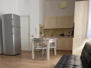 a kitchen with a table and chairs and a refrigerator at Appartamento Civico 16 in Oliena