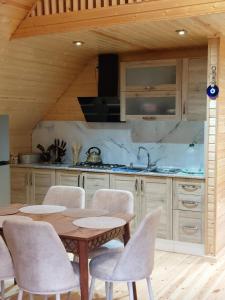 a kitchen with a table and chairs in a room at საოჯახო კოტეჯი ფშუქები in Khoni