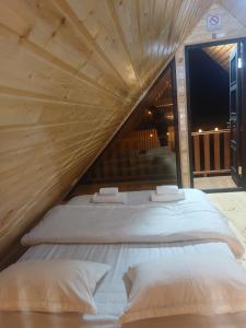 two beds in a room with a wooden ceiling at საოჯახო კოტეჯი ფშუქები in Khoni