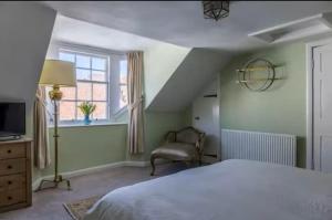 ein Schlafzimmer mit einem Bett und einem Stuhl und einem Fenster in der Unterkunft Hope Cottage by the sea in Saint Monance