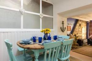 einen Esstisch mit blauen Stühlen und einem Tisch in der Unterkunft Hope Cottage by the sea in Saint Monance + 14 Fotos
