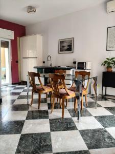 a kitchen with a table and chairs on a checkered floor at Greenhouse Torino in Turin