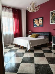 a bedroom with a bed with red walls and a checkered floor at Greenhouse Torino in Turin