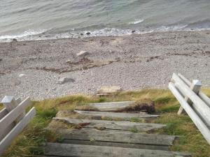 a set of stairs leading to a beach with the ocean at 5 person holiday home in Græsted in Græsted