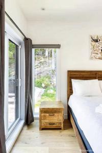 a bedroom with a bed and a large window at Chalet Harmonia, Havre De Paix in Brownsburg