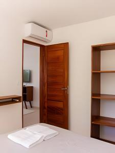 モロ・デ・サンパウロにあるMAR DÁ LIBERDADE com Postal do Farolのベッド1台と木製のドアが備わる客室です。 +32枚の写真