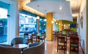 a restaurant with tables and chairs and windows at Del Prado Hotel in Lima
