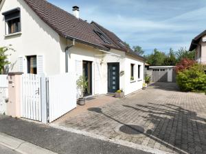 una casa bianca con una recinzione bianca e un vialetto di Maison de village près de Colmar de 90 m2 a Horbourg