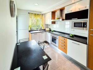 a kitchen with a black counter top in a room at Água do Mar in Armação de Pêra