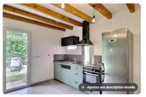a kitchen with a stainless steel refrigerator at Mazet des bruyères in Vallon-Pont-dʼArc