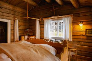 una camera da letto in una baita di tronchi con finestra di Røisheim Hotel & Skysstasjon a Lom