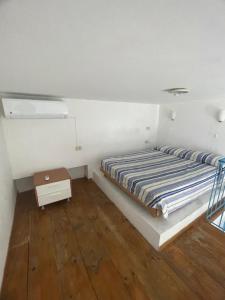 a bed in a room with a wooden floor at Agenzia Isotur LOCANDA NONNA GIULIA 34 in Ponza