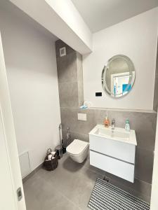 a bathroom with a sink and a toilet and a mirror at Eox Luxury Studio & Apartment Center Cathedral Palas with parking in Iaşi