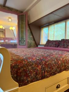 a bedroom with a large bed with a colorful bedspread at Luxurious vintage loft near city center in Groningen +8 photos