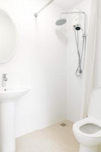 a white bathroom with a toilet and a sink at 1bedroom Lot8 condo in Cebu City +11 photos
